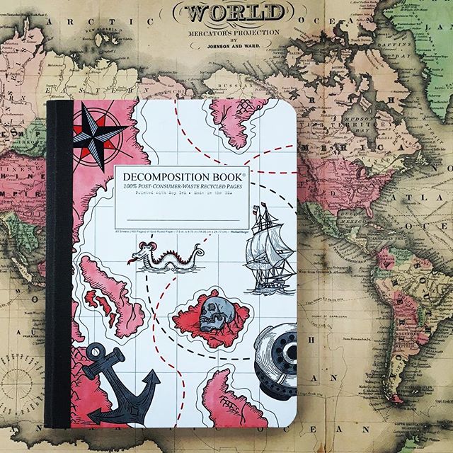 Photo of Decomposition Books notebook with nautical themed cover on top of map