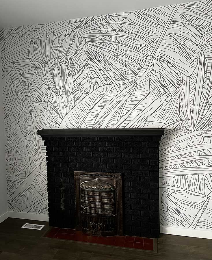 Photo of wall with fireplace and black and white tropical line art mural